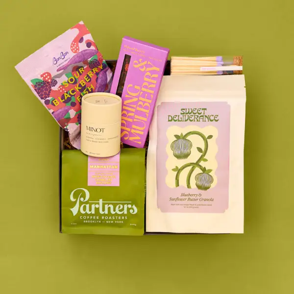 gift box full of coffee and snacks on a green background